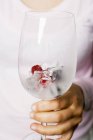Closeup cropped view of person holding berry ice cubes in glass — Stock Photo