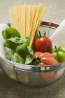 Tomatoe and spaghetti in sieve — Stock Photo