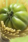 Tomate verde en espaguetis - foto de stock
