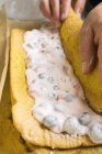 Closeup cropped view of hands rolling sponge roulade — Stock Photo
