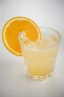 Vue rapprochée de la boisson avec tranche d'orange sur verre — Photo de stock