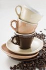 Tazas de café expreso apiladas y granos de café - foto de stock