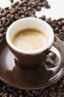 Чашка эспрессо на кофейных зеренах — стоковое фото