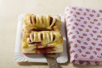Closeup view of two raspberry turnovers on paper plate and towel — Stock Photo