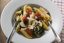 Penne pasta con espinacas y tomates cóctel - foto de stock