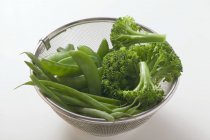Mangetout e brócolis na peneira — Fotografia de Stock