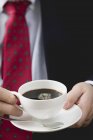 Businessman holding cup of coffee — Stock Photo