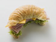 Croissant with ham and cheese — Stock Photo