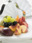 Fresh sliced fruits on serving dish — Stock Photo