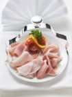 Slices of ham garnished with tomatoes — Stock Photo