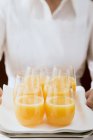 Chambermaid servant du jus d'orange dans des verres — Photo de stock