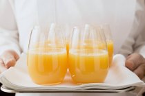 Cameriera che serve succo d'arancia in bicchieri — Foto stock