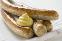 Sausages with mustard on paper plate — Stock Photo