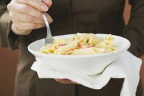 Frau isst Penne-Pasta mit Lachs — Stockfoto