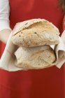 Frau hält frisch gebackene Brote — Stockfoto
