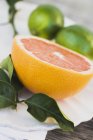 Half of pink grapefruit and limes — Stock Photo