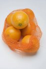 Naranjas frescas maduras en red - foto de stock