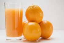 Bicchiere di succo fresco con arance — Foto stock