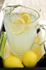 Лимонад в глечику зі скибочками лимона — стокове фото