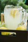 Limonata in brocca con fette di limone — Foto stock