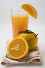 Copo de suco fresco e laranjas — Fotografia de Stock
