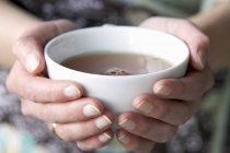 Руки за чашкой чая — стоковое фото
