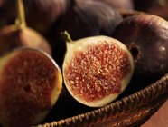 Halved fresh figs in basket — Stock Photo