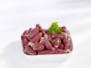 Chicken hearts in dish garnished with parsley — Stock Photo