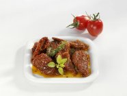 Getrocknete Tomaten in Öl auf einem Teller auf weißer Oberfläche — Stockfoto