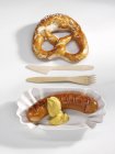 Red sausage with mustard and pretzel — Stock Photo