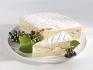 Blue cheese with black grapes — Stock Photo