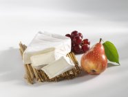 Partly sliced brie with grapes and pear — Stock Photo