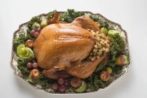 Stuffed turkey on platter with vegetables — Stock Photo