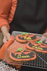 Mani che tengono i biscotti di Halloween — Foto stock