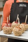 Toffee apples with chopped nuts — Stock Photo