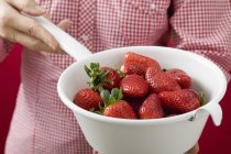 Woman holding strainer with strawberries — Stock Photo