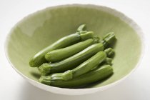 Courgettes fraîches dans un bol vert — Photo de stock