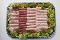Cold cuts on tray with salad garnish — Stock Photo