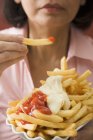 Mulher comer batatas fritas — Fotografia de Stock