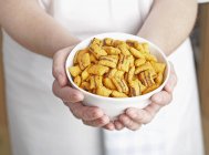 Closeup view of hands holding a bowl of cereal pillows — Stock Photo