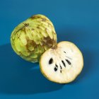 Цельные и вдвое сокращенные плоды черимойи — стоковое фото