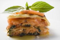 Portion of salmon lasagne with basil — Stock Photo