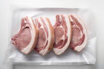 Côtelettes de porc crues sur papier — Photo de stock