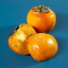 Kaki persimmons with half — Stock Photo