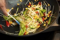 Nahaufnahme ausgeschnittene Ansicht von Hand Gemüse in einem Wok mischen — Stockfoto