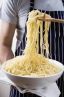Spaghetti in bowl and on server — Stock Photo