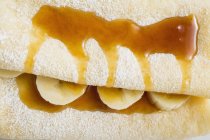 Crpes with bananas and syrup — Stock Photo
