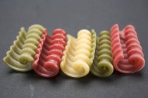 Pâtes riccioli colorées en rangée — Photo de stock