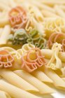 Coloured animal-shaped pasta and penne — Stock Photo