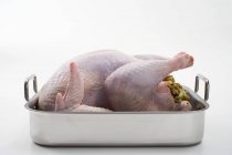 Raw stuffed turkey in roasting tin — Stock Photo
